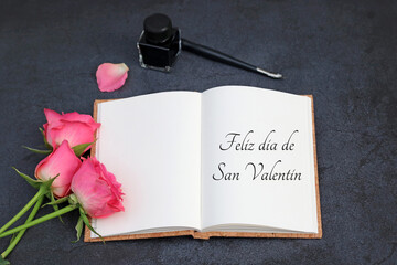 Tarjeta de San Valentín: felicitación por San Valentín escrita en un libro con rosas rojas, tinta y una pluma estilográfica.