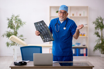 Old male doctor radiologist working in the clinic