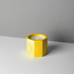 A candle in a candlestick made of acrylic material for home decor.