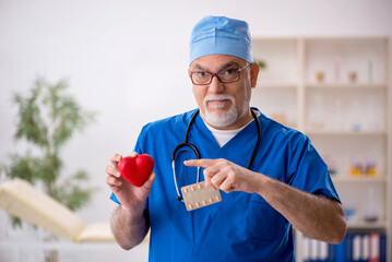 Old male doctor cardiologist working in the clinic