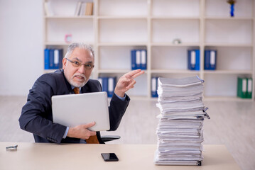 Old male employee unhappy with excessive work in the office