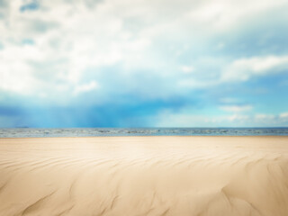 Fototapeta premium Sand. Background of sea sand on the background of the sea. The backdrop. Texture, surface of sea sand. Natural background. Waves of sand. Seascape. Dunes. Copy space