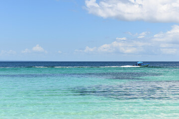 Beautiful bay with a motorized fisherman boat on the Caribbean beach. Cayo Levantado Island, Samana Bay, Dominican Republic.