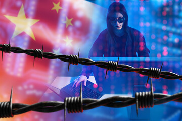 China hacker near barbed wire. Man with computer is engaged in cyber crime. Barbed wire symbolizes...
