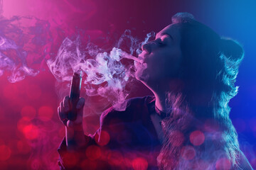 Vaper girl. Young woman with electronic cigarette. Girl blows steam from vape from mouth. Vaper...