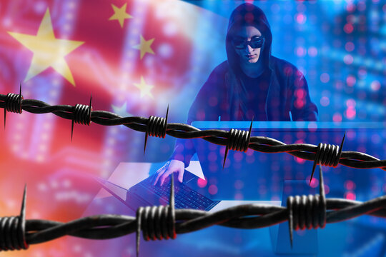 China hacker near barbed wire. Man with computer is engaged in cyber crime. Barbed wire symbolizes arrest and imprisonment. Arrest of China hacker. Male hacker near flag of China. Cyber crime