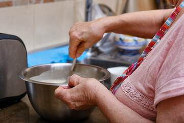 Close-up of the hands of an elderly woman with arthritis while cooking
