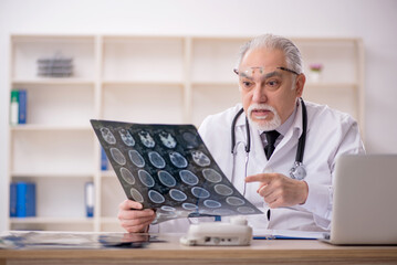 Old male doctor radiologist working in the clinic