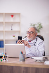 Obraz na płótnie Canvas Old male doctor in telemedicine concept