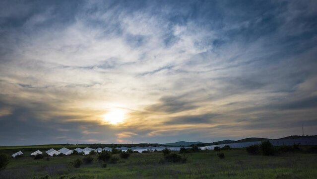 Solar panels to generate energy from the sun's rays are installed in the meadows under a blue sky with sun