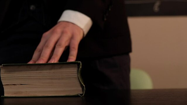 The teacher closes the book at school close-up