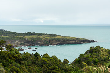 Fototapeta na wymiar Raue Westküste Neuseelands mit Meer, Urwald, Wellen und Felsen.