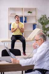 Obraz premium Young male patient visiting old male doctor