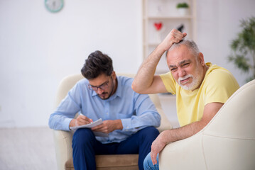 Fototapeta premium Old man visiting young male psychotherapist