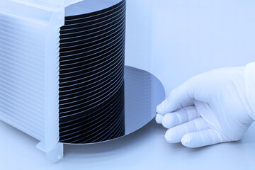 Silicon wafer inspection. A batch of silicon wafers packed in a plastic storage box in the clean room of a semiconductor foundry ready for microchip production. Banner. - obrazy, fototapety, plakaty
