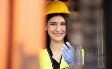 Female foreman using radio while driving forklift vehicle at shipping container yard. Industrial...