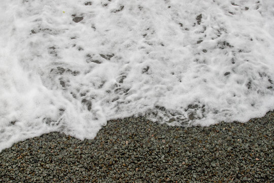 sea, foamy wave on a pebble beach. © Prikhodko