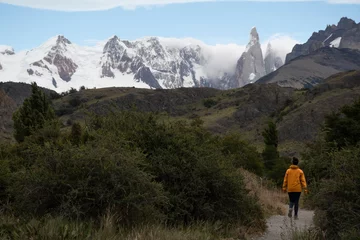 Acrylic prints Cerro Torre chica caminando hacia al cerro torre con una chaqueta amarilla