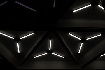 Triangular fluorescent lamps. Ceiling design. Interior details. Futuristic light.