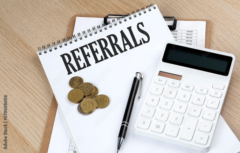 Poster referrals text on a notebook with chart and calculator and coins, business concept
