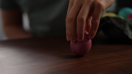 Young man spin easter egg on walnut table
