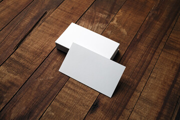 Blank white business cards on wooden background. Mockup for branding identity.