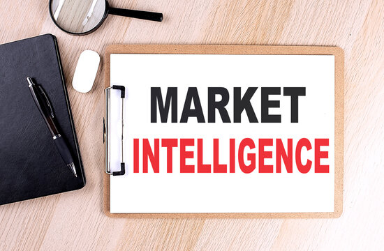 MARKET INTELLIGENCE text on clipboard on wooden background
