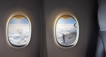 Naklejka premium Clouds and wings seen outside the window of an airplane in flight
