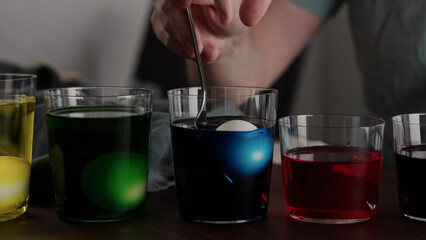 Man painting eggs for easter with various colorings