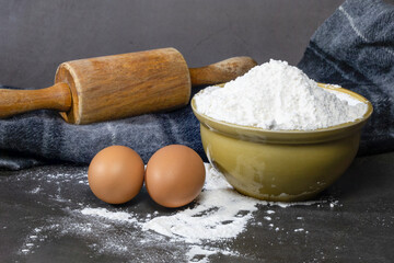 All-purpose flour in a brown ceramic bowl and eggs