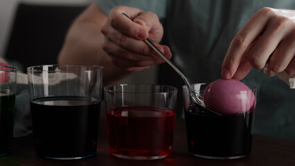 Man painting eggs for easter with various colorings