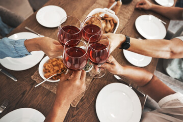 Fototapeta na wymiar Top view, hands and toast with red wine at dinner table for new year celebration in home. Party, cheers and group of friends, men and woman with alcohol or beverage to celebrate with delicious food.