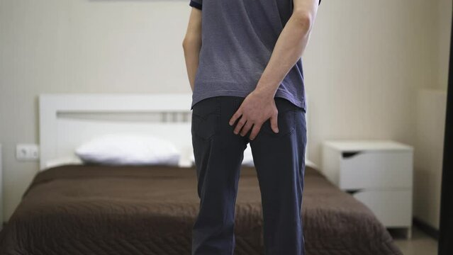 Hemorrhoidal pain, man suffering from hemorrhoids at home, health problems concept