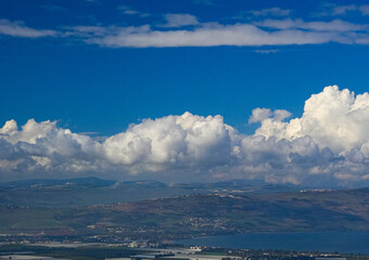 Fototapeta premium umm qais - irbid, jordan 06- Feb- 2023 - View of the city of Tiberias and The Sea of Galilee in Israel with blue sky and light clouds