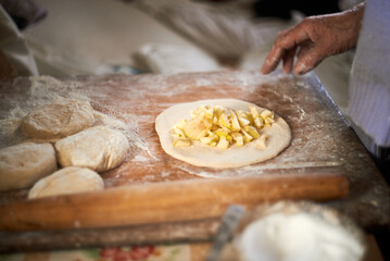 Process of cooking apple pies on wooden table