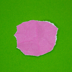 Pink torn paper piece isolated on green background