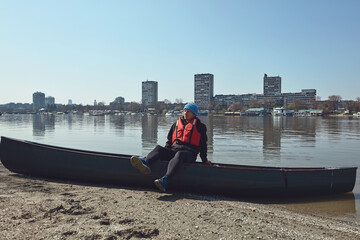Man paddling with a canoe on a Danube river in urban area, small recreational escape, hobbies and...