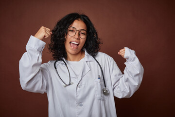 Young colombian doctor woman with stethoscope raising fist after a victory, winner concept.