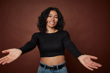 Young colombian curly hair woman isolated on brown background showing a welcome expression.
