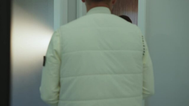 Woman assistant walking with patient in light dental clinic to medical room. Hygiene and healthy