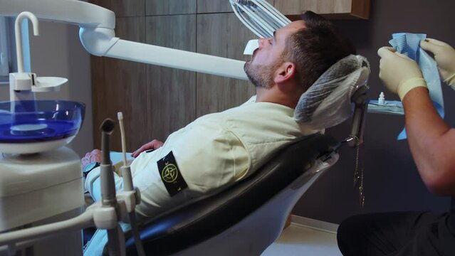 Close up hands dentist preparing patient for the procedure in light dental clinic. Hydience and healthy