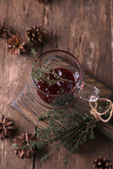 Tea with jam and thyme in a transparent teapot