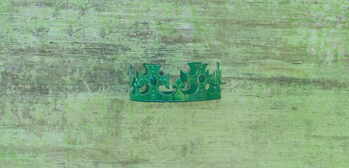 green crown on green wooden background