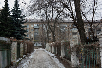 Quiet winter snowy streets, nooks and crannies of the street with houses, high fences in the city of Dnipro, ukraine.