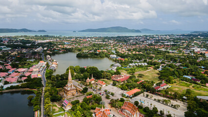 Drone aerial view , traveler with backpack traveling into beautiful pagoda in Wat Chalong or Chalong temple at Phuket town, Thailand. It's most popular thai temple in Phuket Thailand.