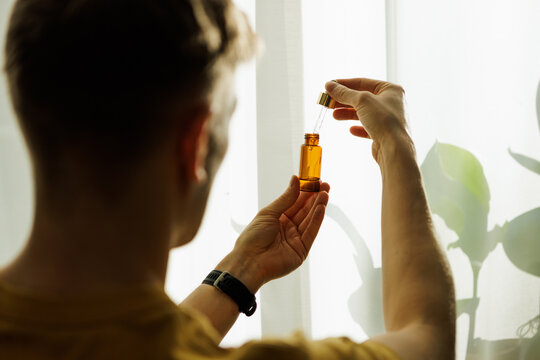 Positive Professional Taking Care of Their Mental and Physical Health with CBD Tincture for Stress and Anxiety Relief. Holding a Bottle of Hemp Oil, a Popular Supplement for a Healthy Lifestyle