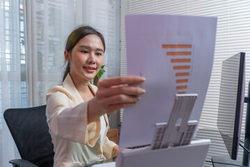 Asian woman scanning business documents to convert from paper to computer.
