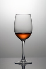 Rose wine in a glass close-up, isolated in backlight