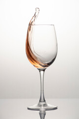 Splash of rose wine in glass, frozen motion