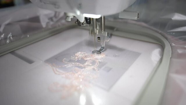 The sewing machine embroiders a pattern on the fabric
